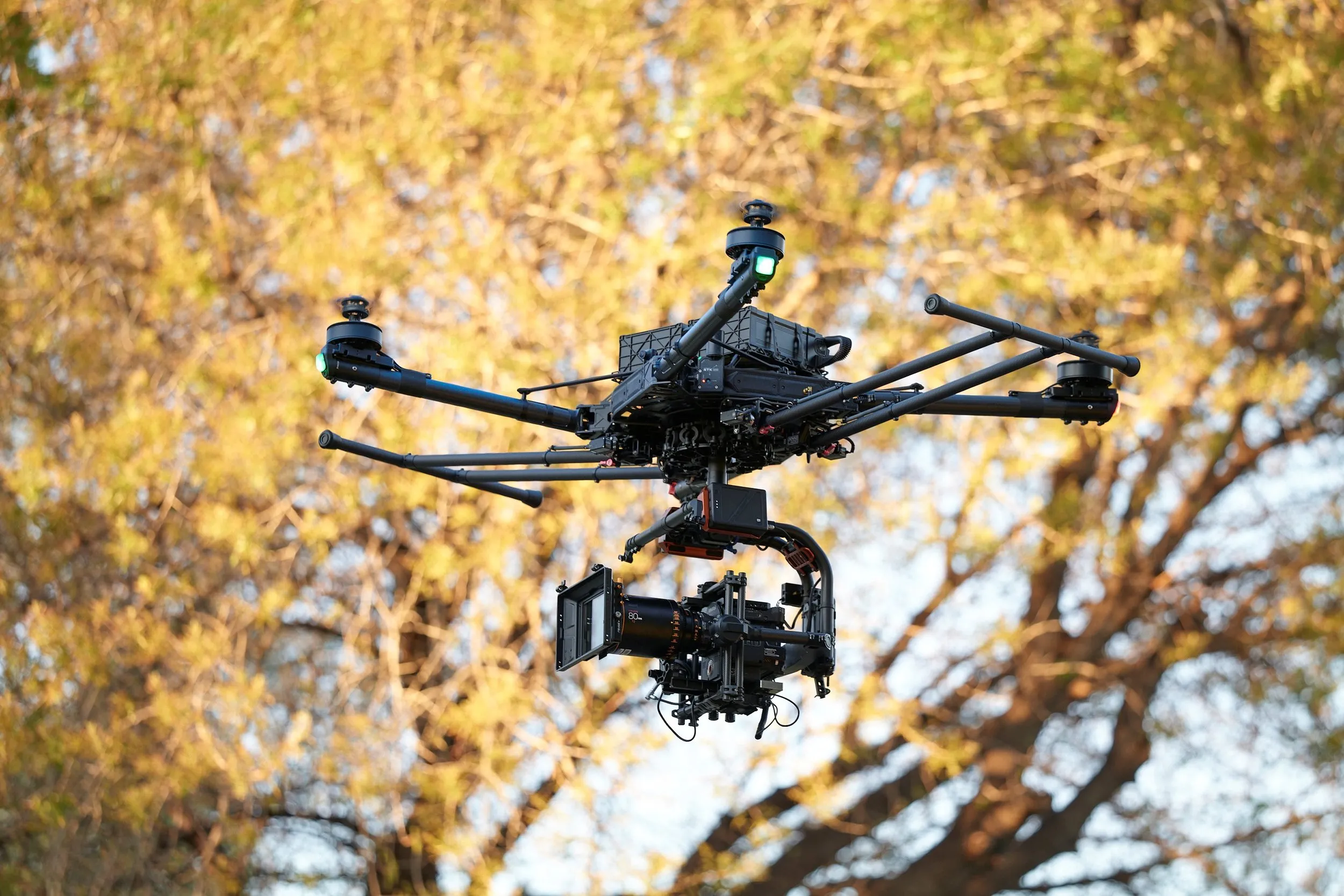 Freefly ALTA X flying a RED camera and Atlas anamorphic lens past autumn desert trees